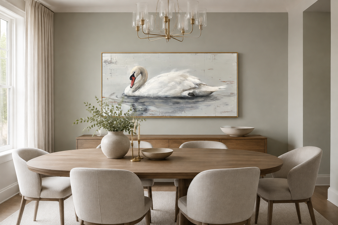 Framed white swan canvas painting above a dining table in a rustic farmhouse-style room.