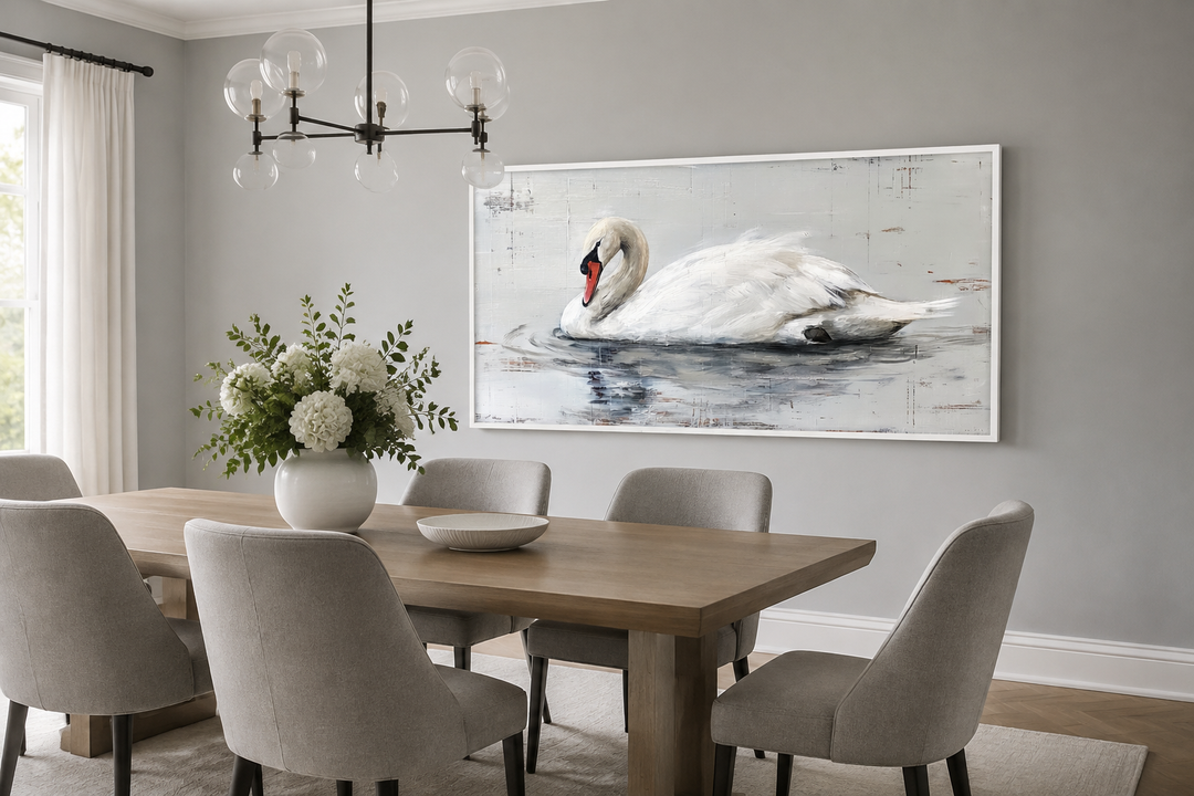 Large horizontal white swan canvas painting in a white frame above a dining table.