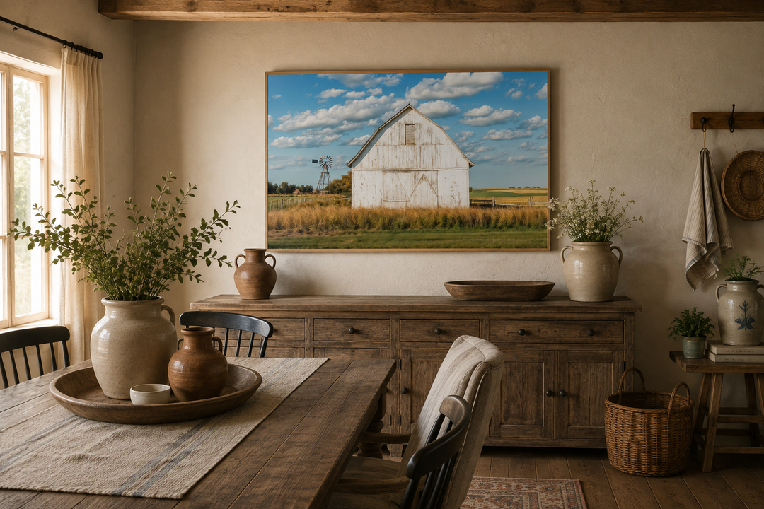 Framed canvas wall art of a weathered white barn and windmill in a rustic farmhouse dining room.