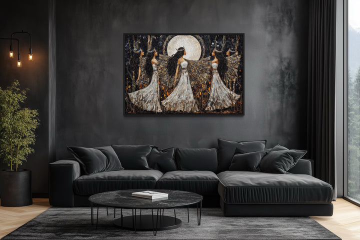 Wiccan Goddesses Dance framed canvas wall art above a black sofa in a dark, modern living room.