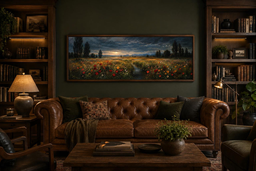 Panoramic wildflower meadow at dusk wall art in a slim frame above a brown leather sofa.