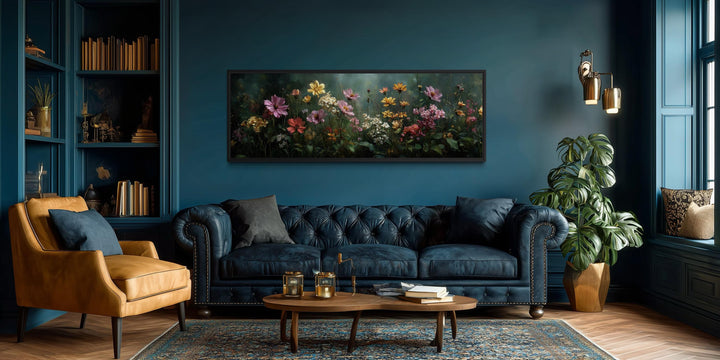 Wide horizontal canvas print of a wildflower meadow on a dark green background above a blue sofa.