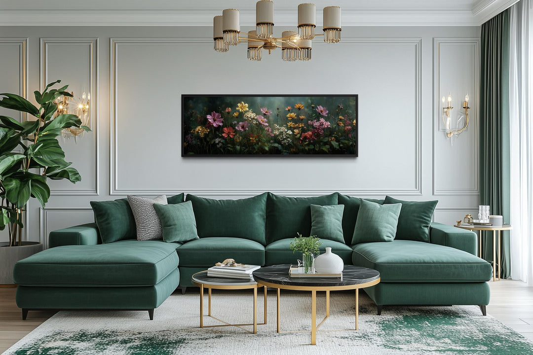 A wide horizontal canvas of a wildflower meadow with a green background hangs above a green sofa.
