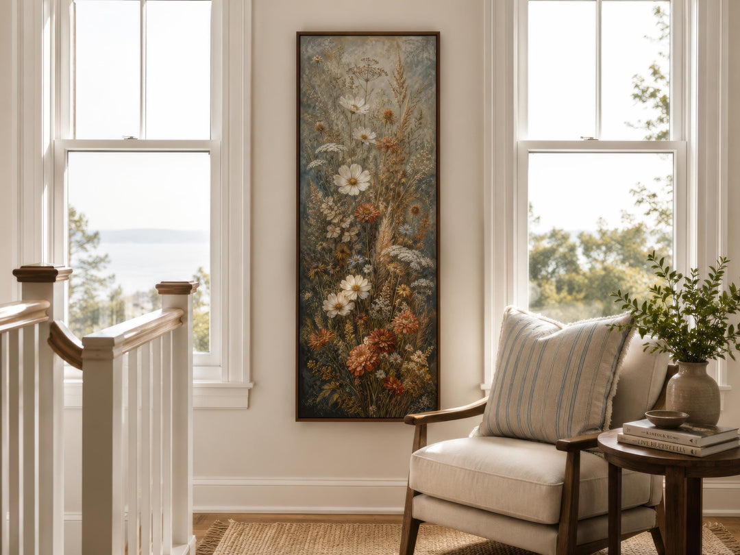 Tall vertical canvas print of wildflowers in blue, rust, and cream tones on a neutral wall.
