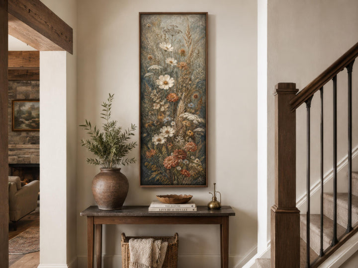 Tall vertical wildflower canvas print with blue, rust, and cream botanical blooms in a wood frame.