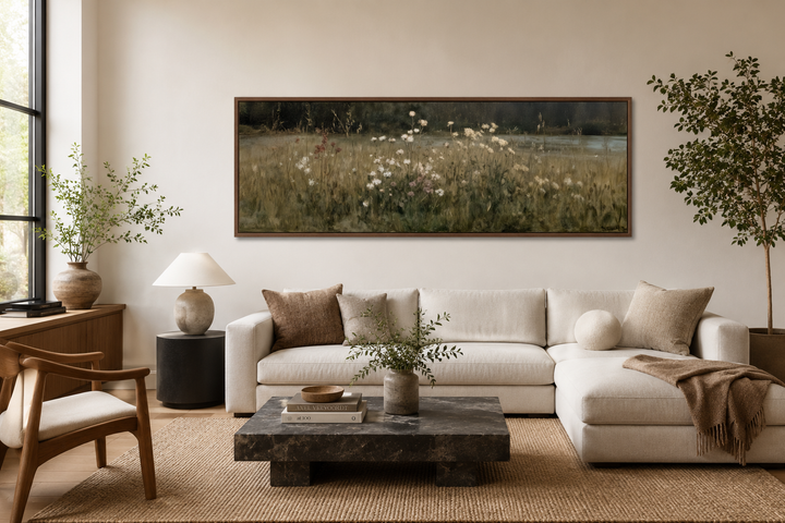 Long narrow wildflower meadow wall art in a neutral landscape style above a white sectional sofa.