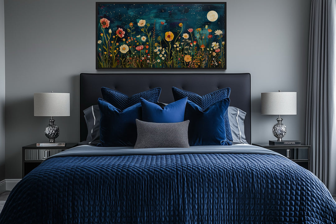 Large horizontal wall art of a moonlit wildflower field above a bed with blue bedding.
