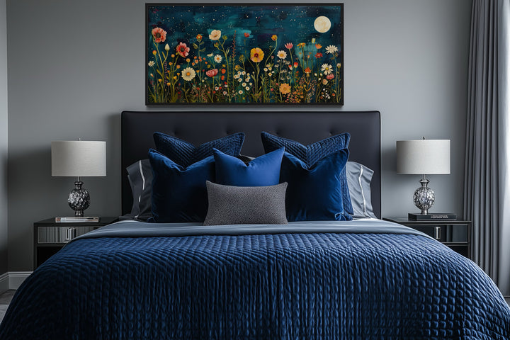 Large horizontal wall art of a moonlit wildflower field above a bed with blue bedding.