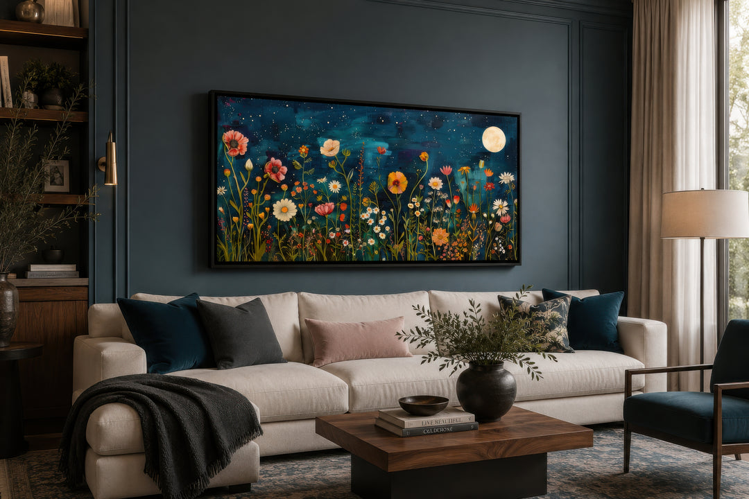 Large horizontal wall art of a wildflower field at night under a full moon in a dark living room.
