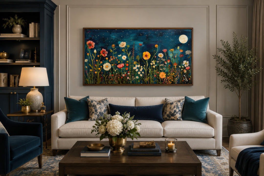 Large horizontal wall art of a wildflower field at night under a full moon above a white sofa.