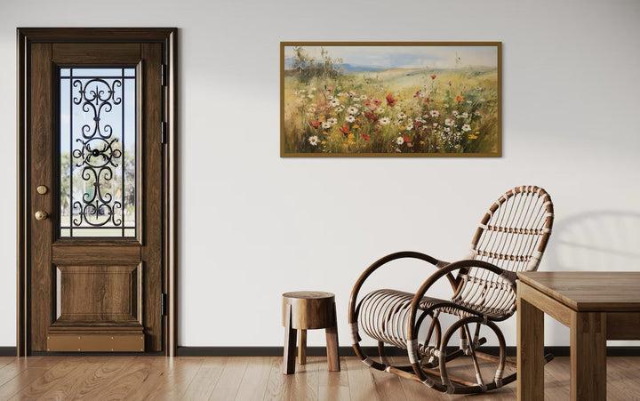Wildflowers field farmhouse canvas wall art in a panoramic frame above a rocking chair.