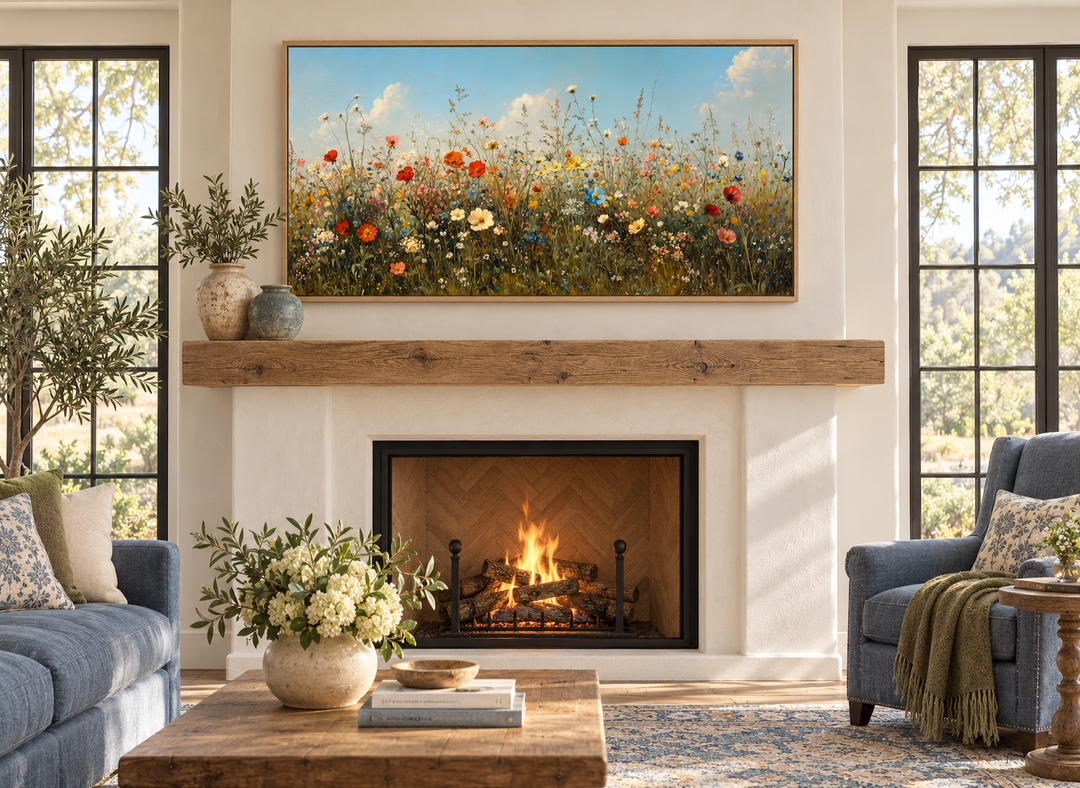 Large framed canvas art of a colorful wildflower field above a rustic fireplace in a cozy room.