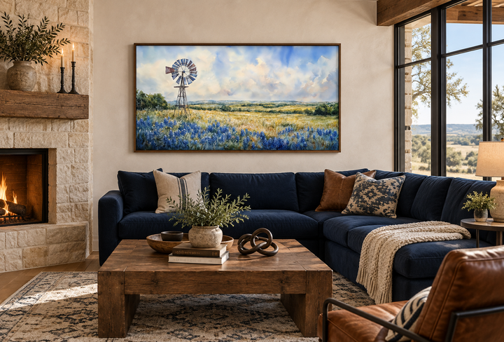 Panoramic canvas wall art of a windmill over a field of bluebonnets above a navy sectional sofa.
