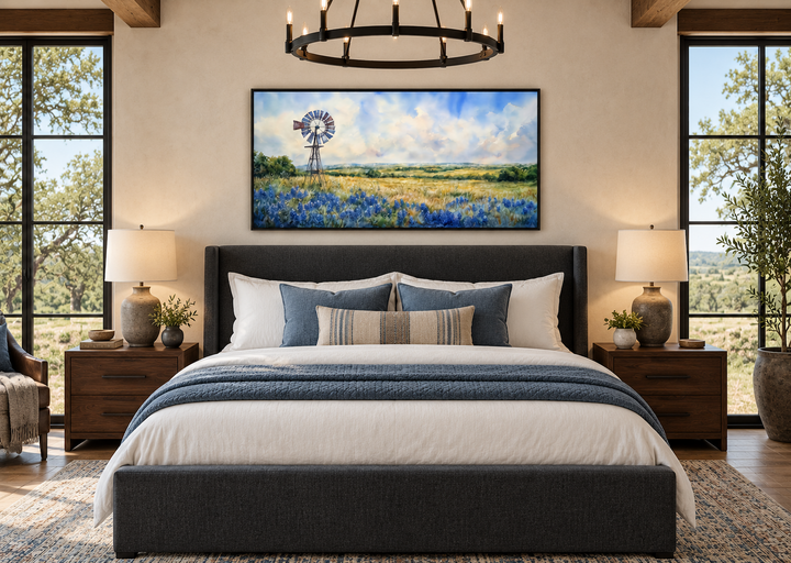 Panoramic canvas wall art of a windmill over a field of bluebonnets above a bed in a bedroom.
