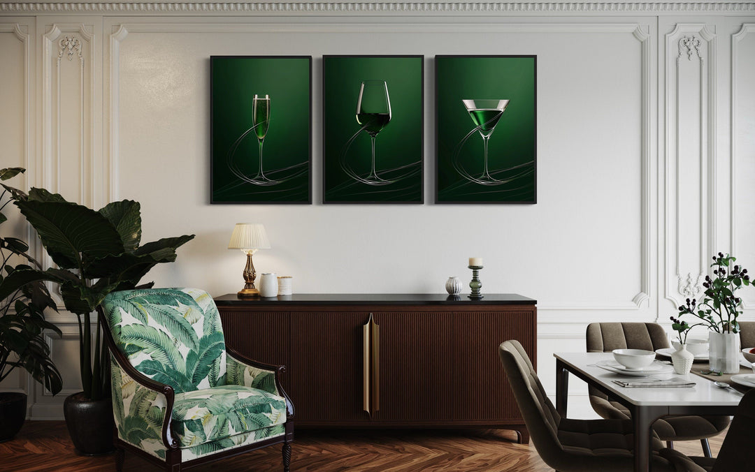 Three-piece framed canvas art of green-tinted wine, martini, and champagne glasses on a dark wall.