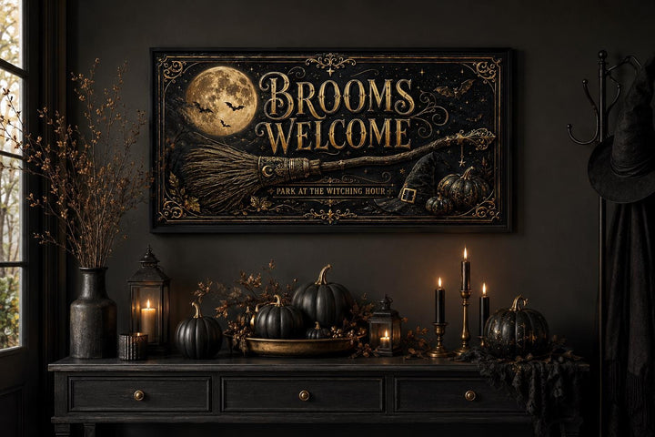 Brooms Welcome sign with a full moon and broom above a console with black pumpkins and candles.