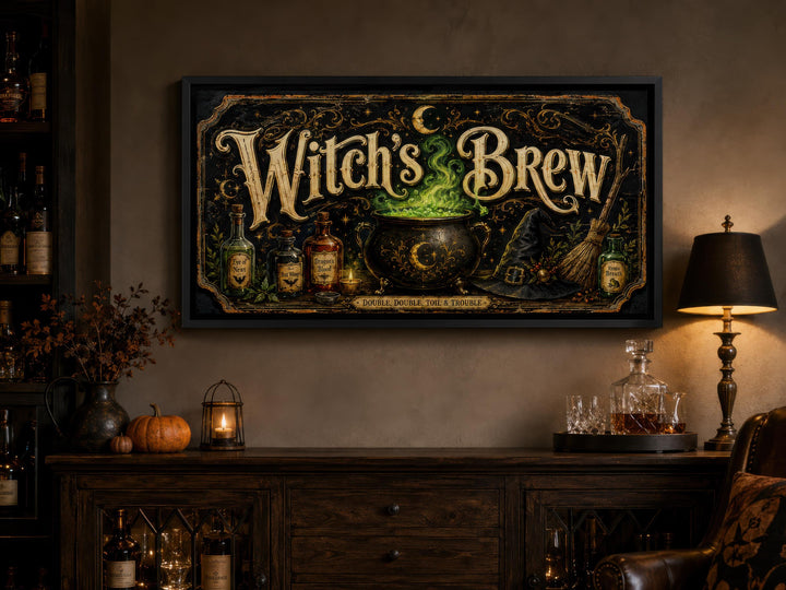 Witch's Brew vintage-style black and gold canvas print above a dark wood sideboard with pumpkins.