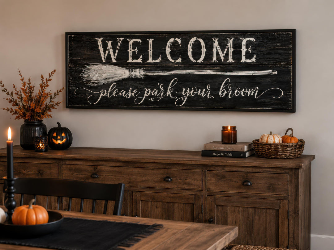 Witchy Halloween wall art sign reading "Welcome please park your broom" above a wooden console table.