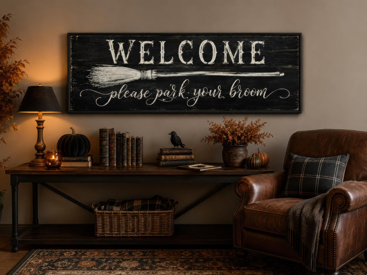 Witchy Halloween wall art sign reading "Welcome please park your broom" above a console table.