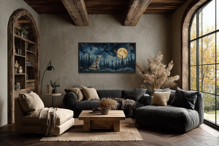 A horizontal canvas of a wolf under a full moon hangs in a rustic, earth-toned living room.