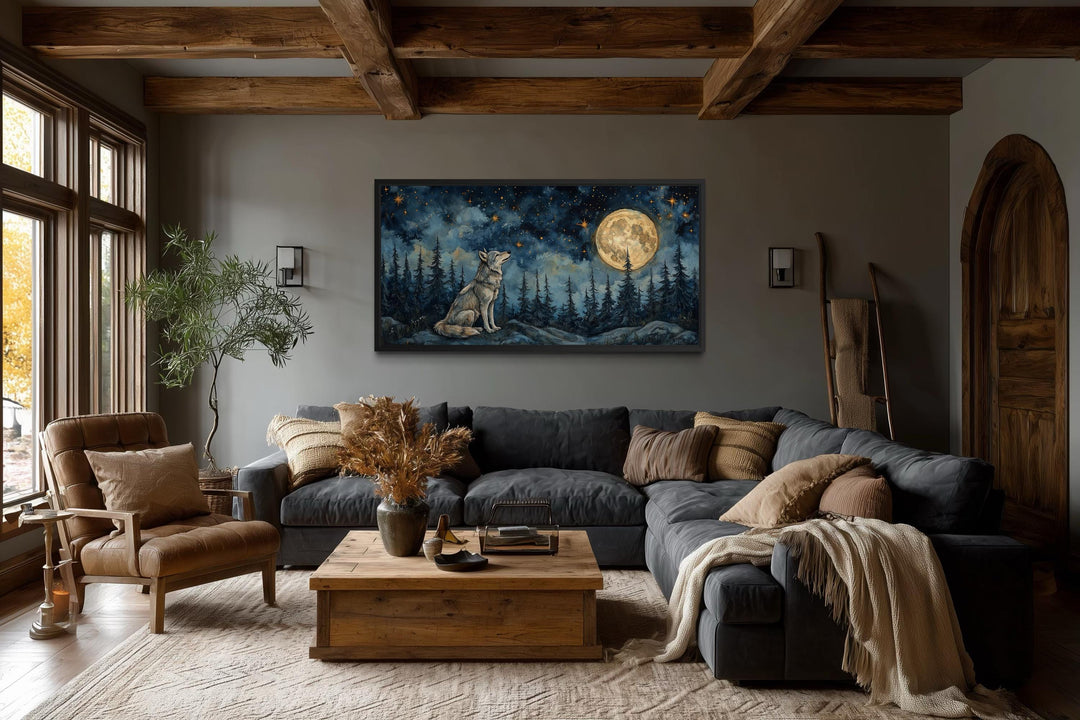 Horizontal canvas art of a wolf under a full moon in a forest, hung in a rustic living room.