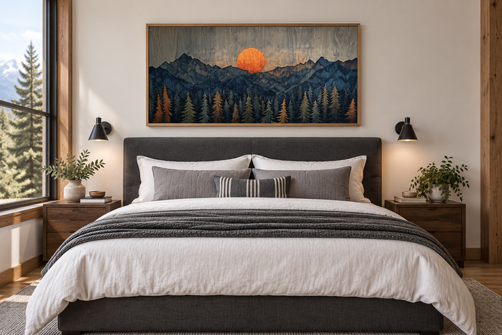 Sunset over mountain and forest wooden effect framed canvas wall art above a bed in a rustic room.