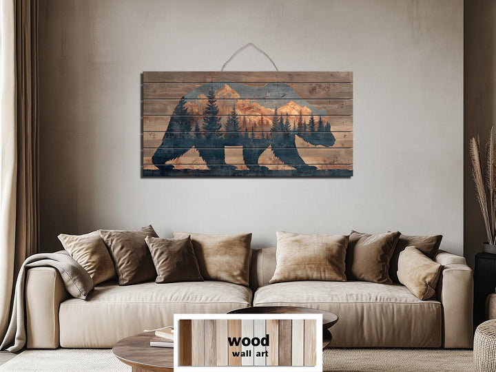 A horizontal wooden wall art piece featuring a bear silhouette filled with a mountain forest scene.