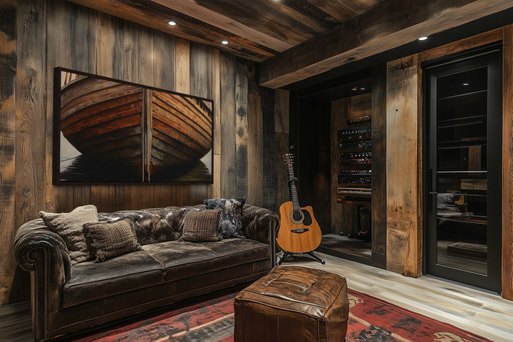 Framed canvas print of a rustic wooden boat on a dark wood wall in a cozy cabin living room.