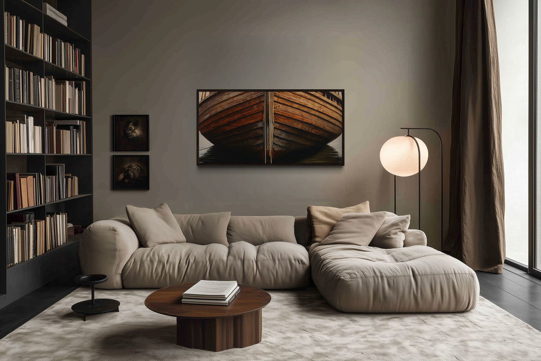 Framed canvas print of a rustic wooden boat hull hanging above a modern beige sectional sofa.
