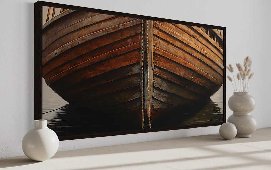 Framed canvas print of a rustic wooden boat hull on water, displayed in a minimalist room.