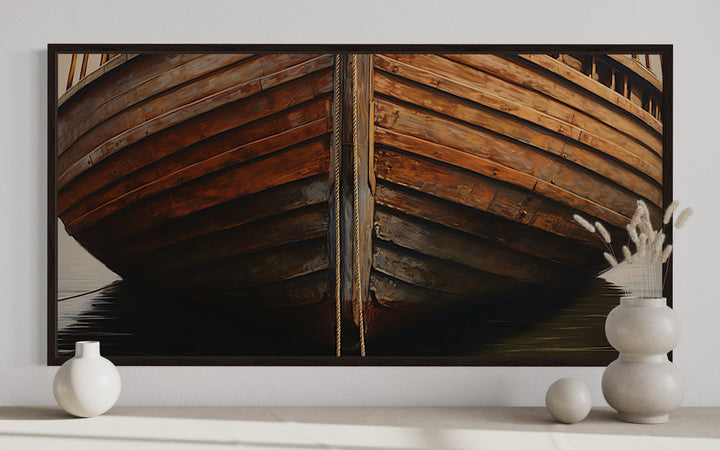 Framed canvas print of a rustic wooden boat bow, displayed above a shelf with white ceramic vases.