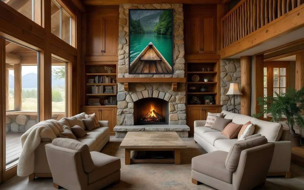 Vertical framed canvas wall art of a wooden canoe on an emerald green lake above a stone fireplace.