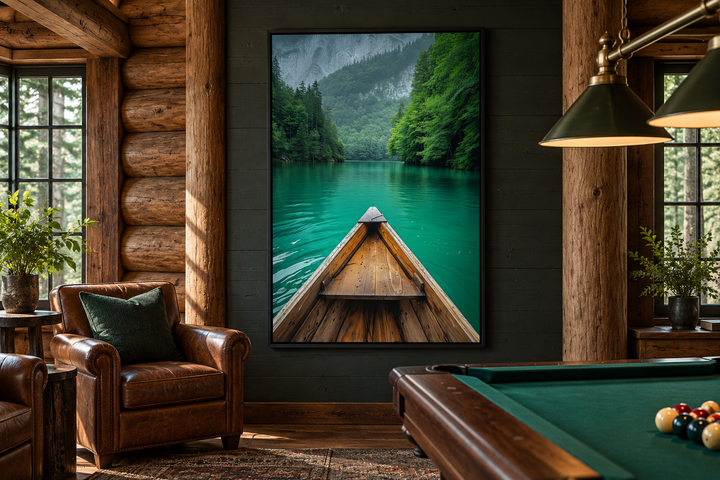 Vertical framed canvas wall art of a wooden canoe on an emerald green lake in a rustic cabin room.