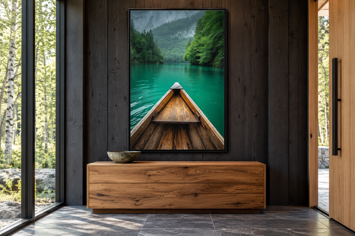 Vertical framed canvas wall art of a wooden canoe on an emerald green lake in a modern cabin room.