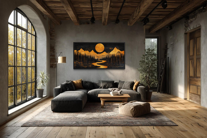 Wooden mountain river under glowing moon framed canvas wall art in a rustic living room.