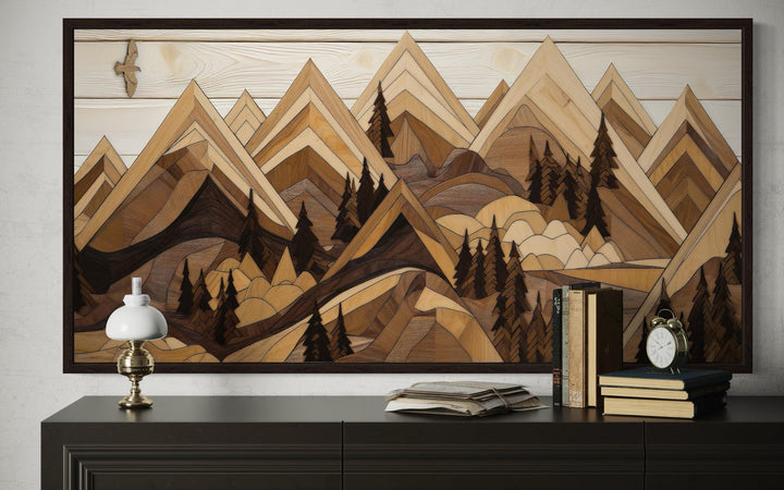 Framed canvas wall art of a wooden mountain landscape with a soaring eagle above a dark sideboard.