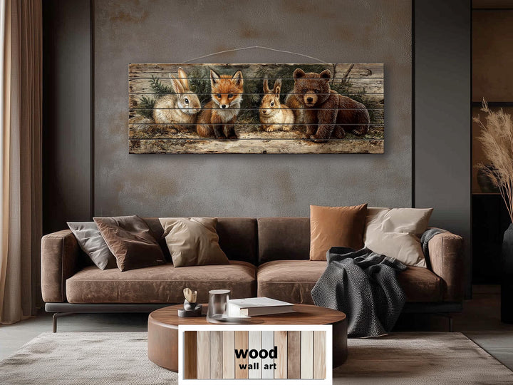 Panoramic woodland animal wall art on distressed wood planks above a brown sofa in a rustic room.