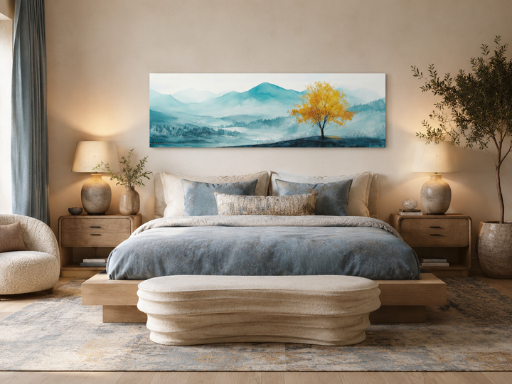 Yellow tree on teal mountain landscape long horizontal wall art above a bed in a modern bedroom.