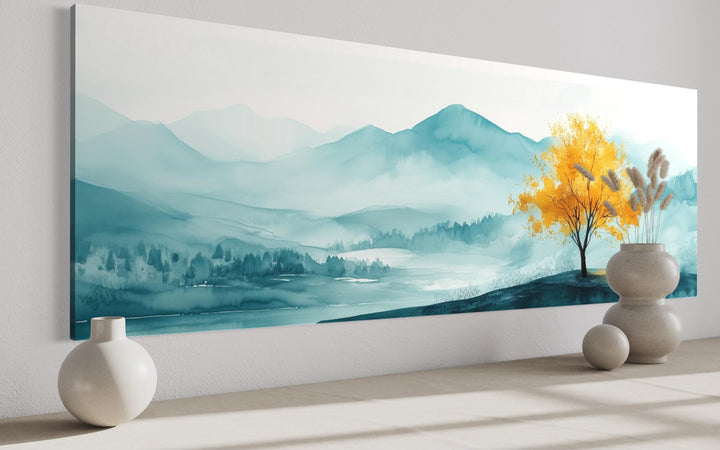 Long horizontal wall art of a golden yellow tree against a misty teal mountain landscape.