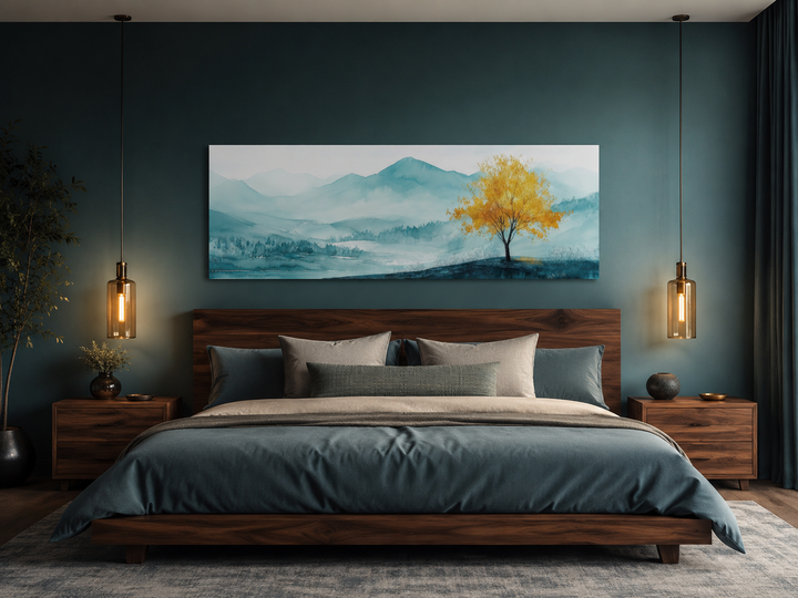 Yellow tree on teal landscape long horizontal wall art hanging above a bed in a modern bedroom.