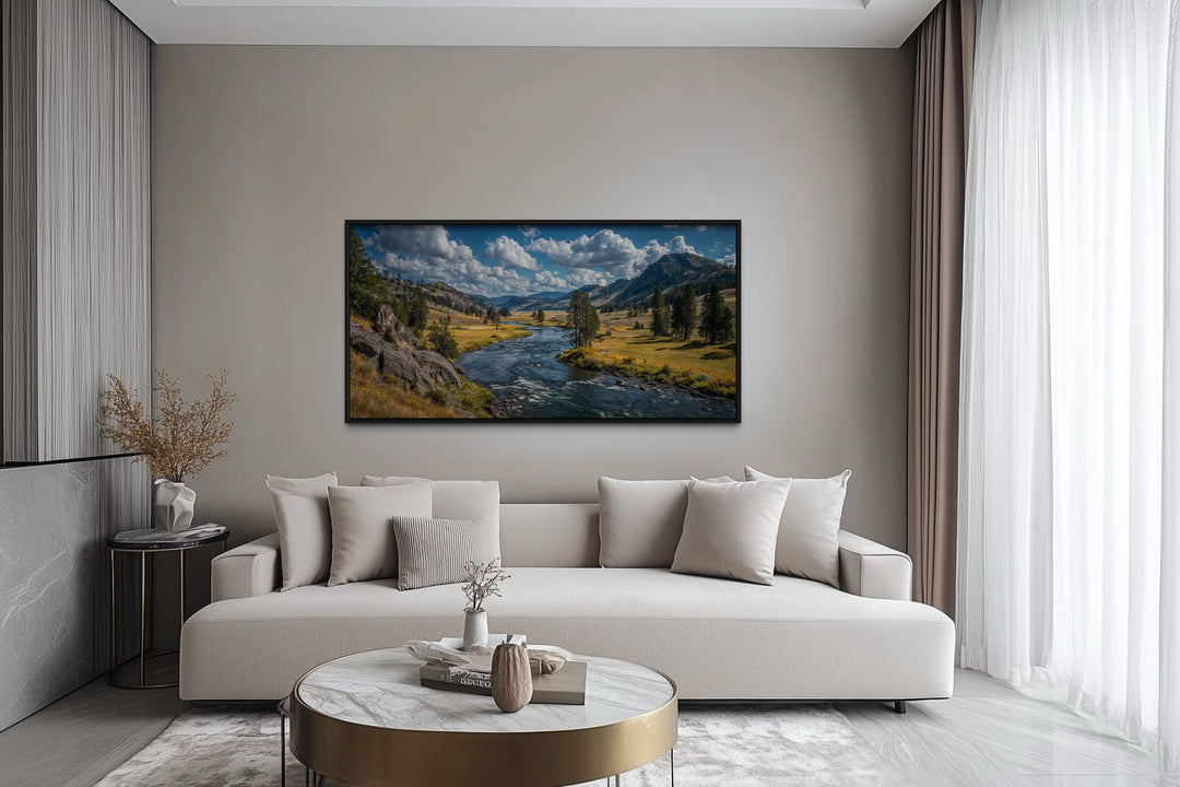 Framed panoramic canvas of Yellowstone National Park landscape above a modern sofa in a living room.