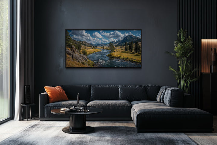 Framed panoramic canvas of Yellowstone National Park landscape hanging above a dark grey sofa.