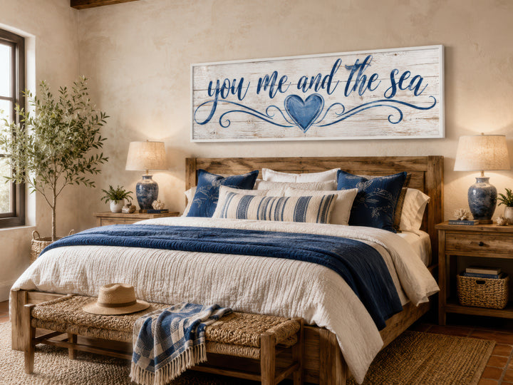 You Me And The Sea wall art in a coastal bedroom with navy and white bedding and rustic wood bed.