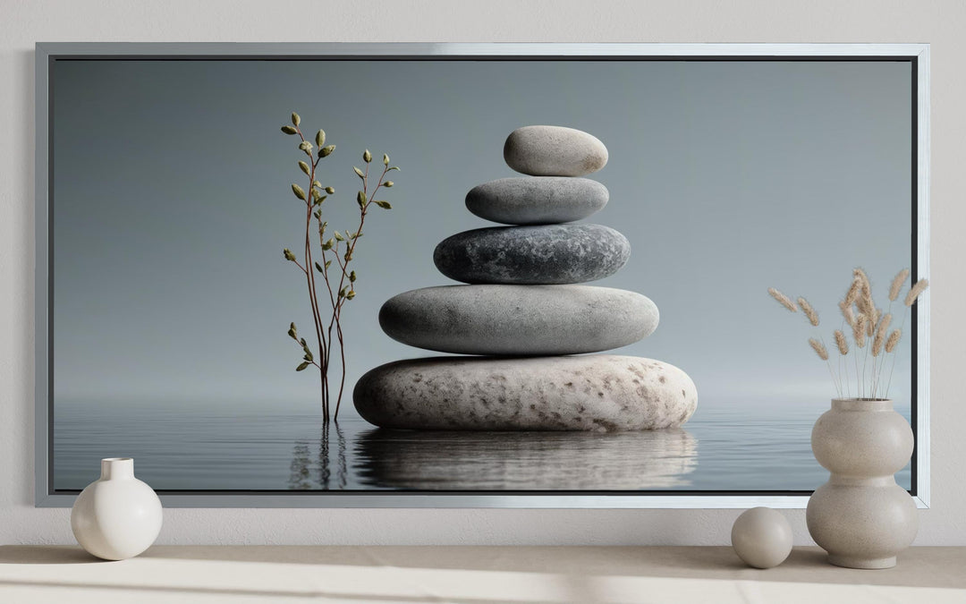 Zen stacked stones horizontal grey minimalist wall art in a silver frame on a neutral shelf.