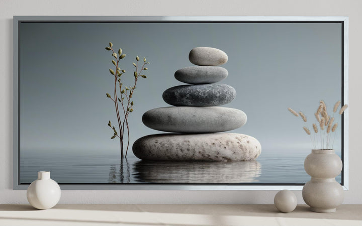 Zen stacked stones horizontal grey minimalist wall art in a silver frame on a neutral shelf.