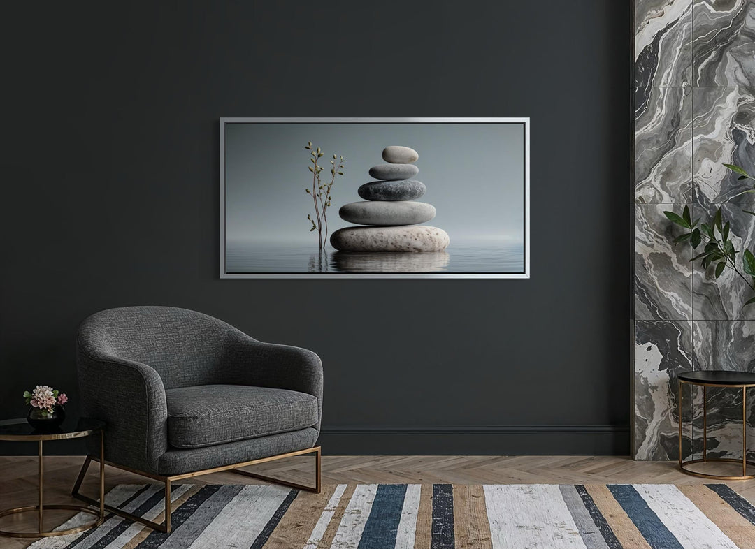Horizontal minimalist wall art featuring a stack of balanced stones on a dark grey wall.