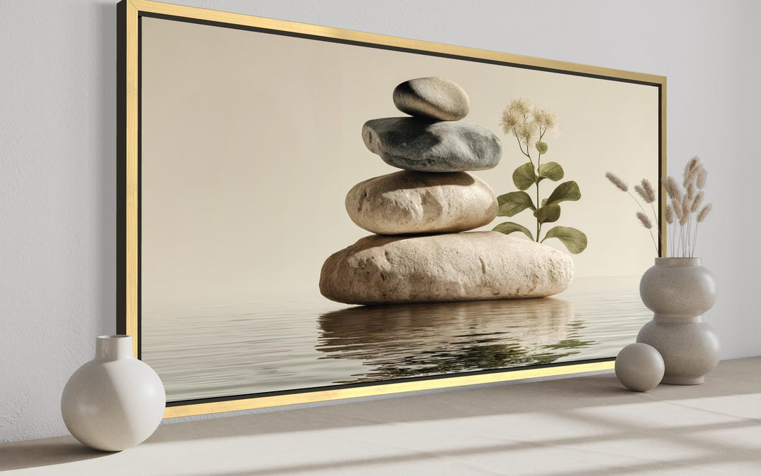 Zen stacked stones minimalist meditation wall art in a gold frame on a neutral wall.