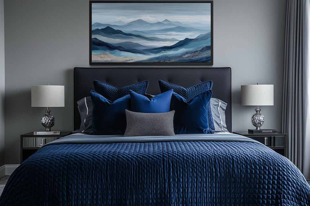 Blue mountain serene nature landscape canvas wall art hanging above a bed with blue bedding.