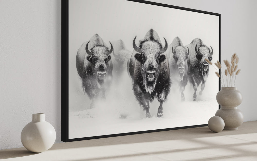 a black and white photo of a herd of bison