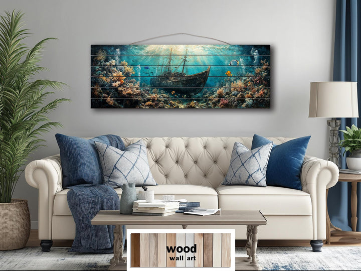 Sunken shipwreck scene printed on a horizontal distressed wood wall art piece above a sofa.